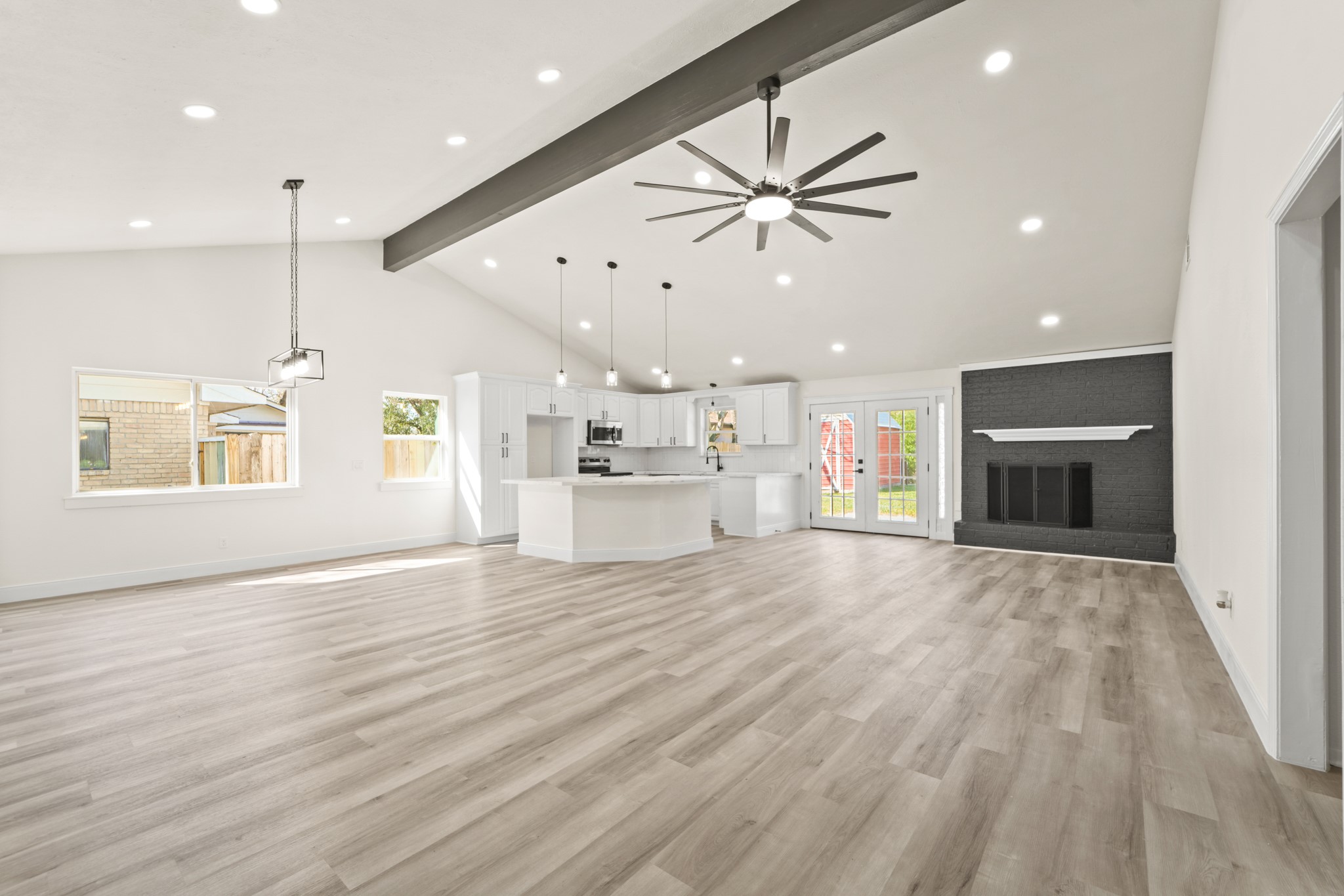 13102 Maxim Drive Houston, TX 77065 - Photo 14 of 45 an empty room with wooden floor a ceiling fan and kitchen view
