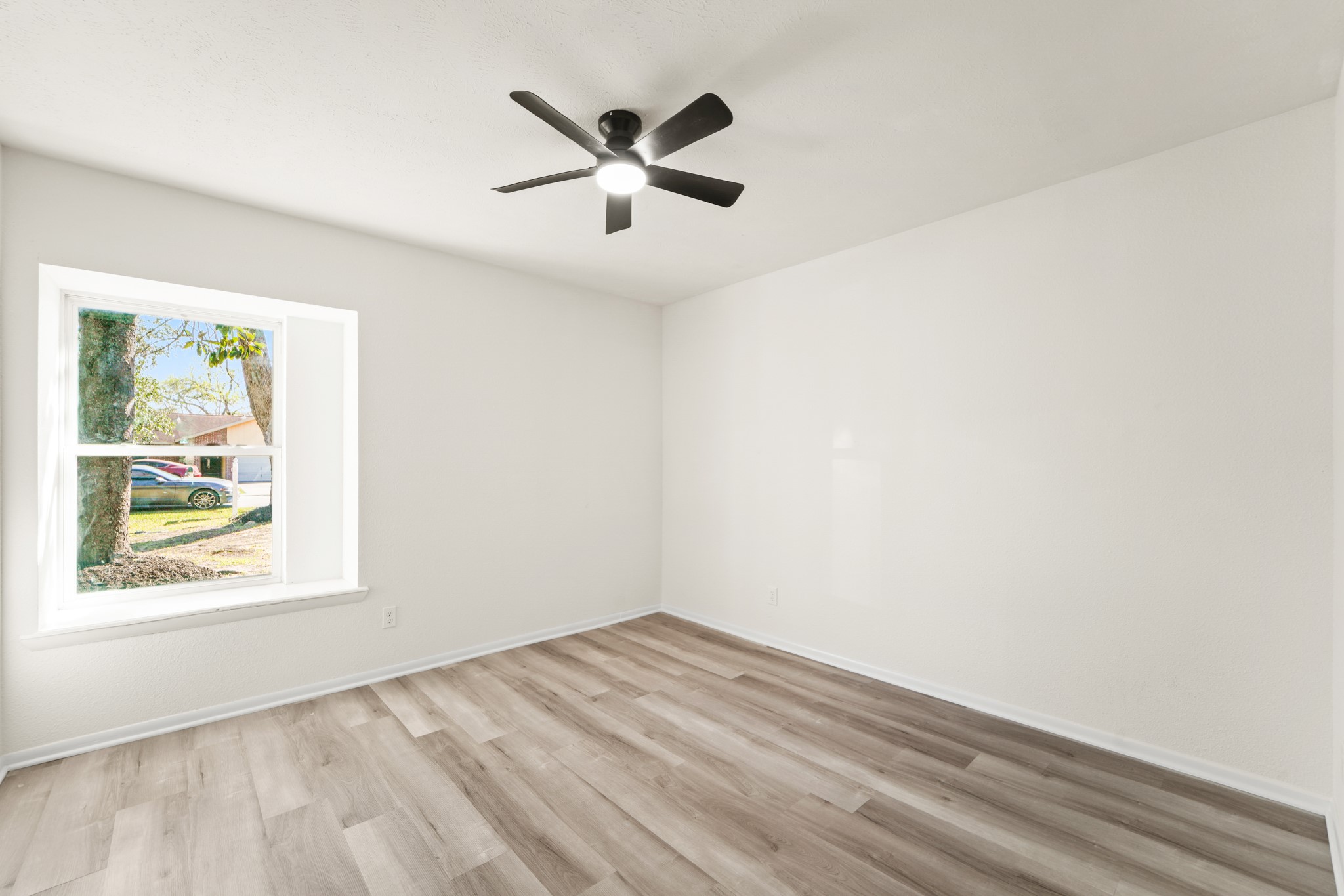 13102 Maxim Drive Houston, TX 77065 - Photo 19 of 45 a view of empty room with wooden floor and fan