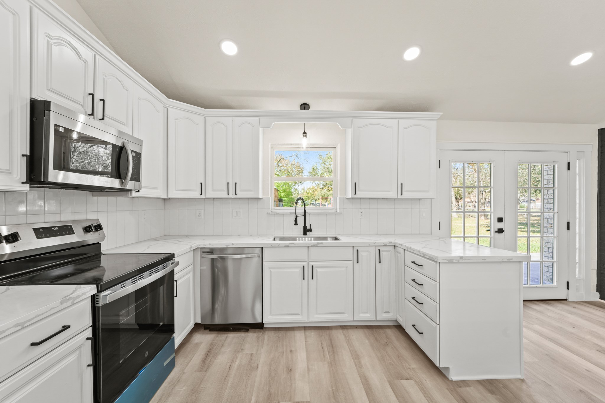 13102 Maxim Drive Houston, TX 77065 - Photo 10 of 45 a kitchen with stainless steel appliances a white cabinets sink and stove top oven