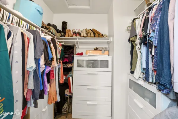 a view of walk in closet with clothes and shoes