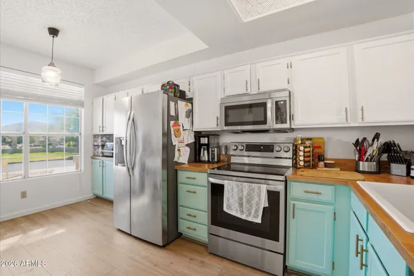 a kitchen with stainless steel appliances granite countertop a refrigerator stove and sink