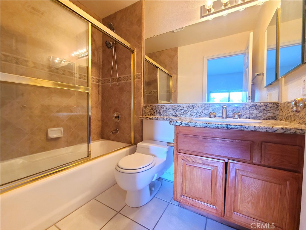 306 Edgemont Drive Redlands, CA 92373 - Photo 13 of 24 a bathroom with a granite countertop sink toilet mirror and bathtub