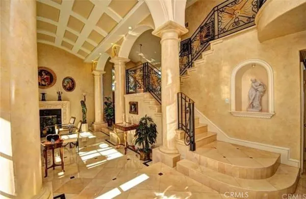 a view of a entryway with a flower garden and couches chairs
