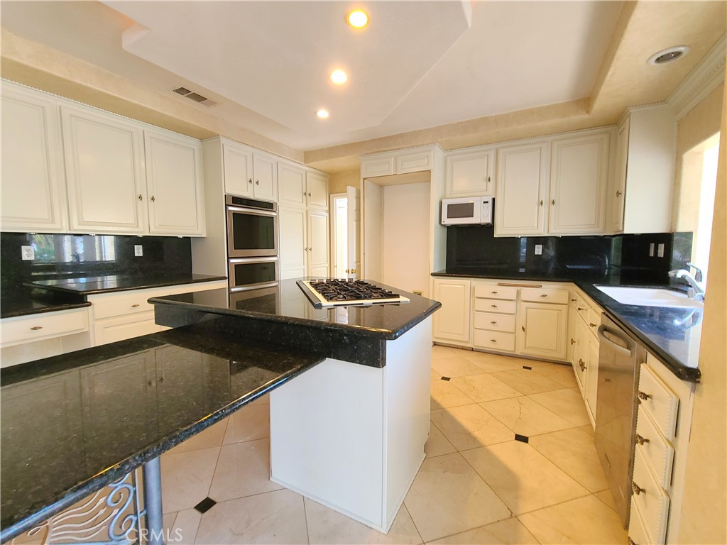 306 Edgemont Drive Redlands, CA 92373 - Photo 10 of 24 a kitchen with granite countertop a sink a stove and cabinets