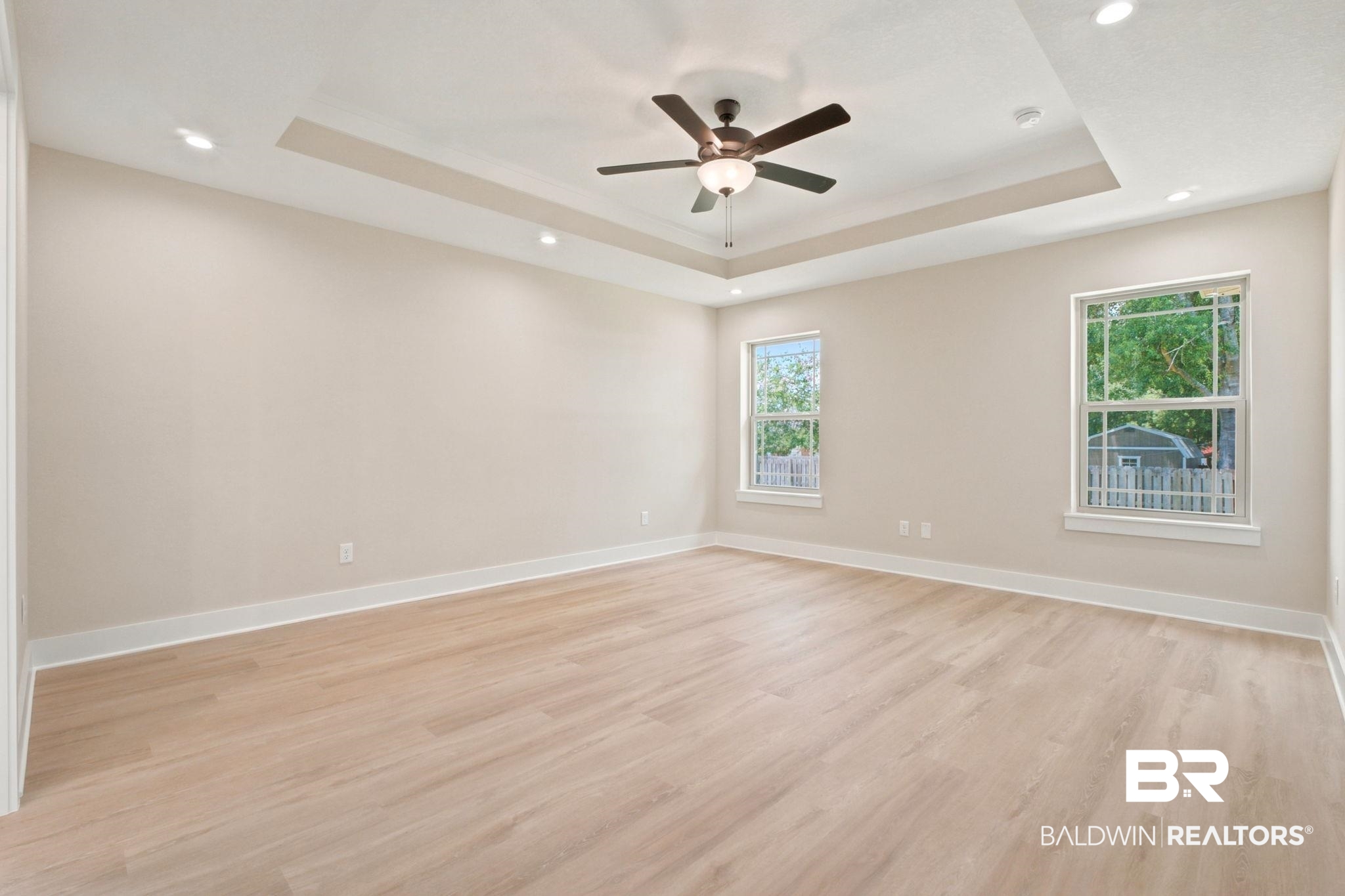 32656 Arbor Ridge Circle Lillian, AL 36549 - Photo 13 of 56 Spacious room featuring light-toned wood-finish flooring, a tray ceiling with recessed lighting, and a ceiling fan