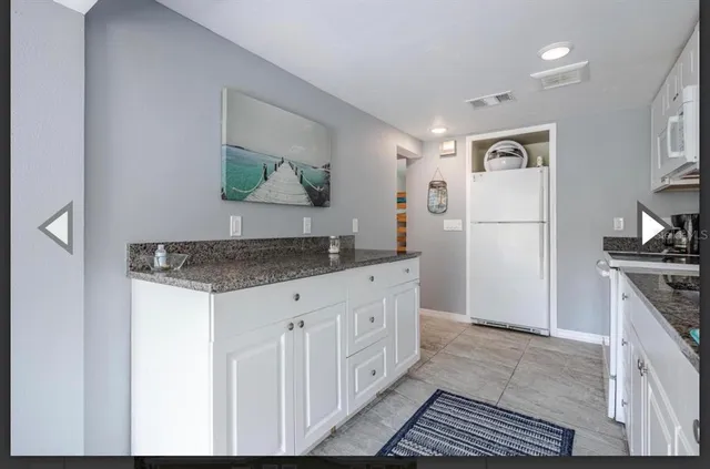 a kitchen with stainless steel appliances granite countertop a refrigerator and a stove