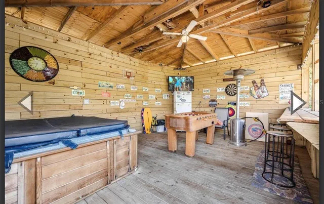 a living room with stainless steel appliances granite countertop furniture and a wooden floor