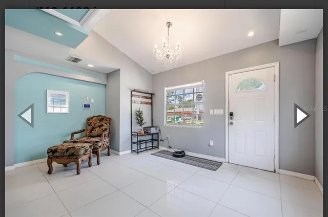 a living room with furniture and a chandelier