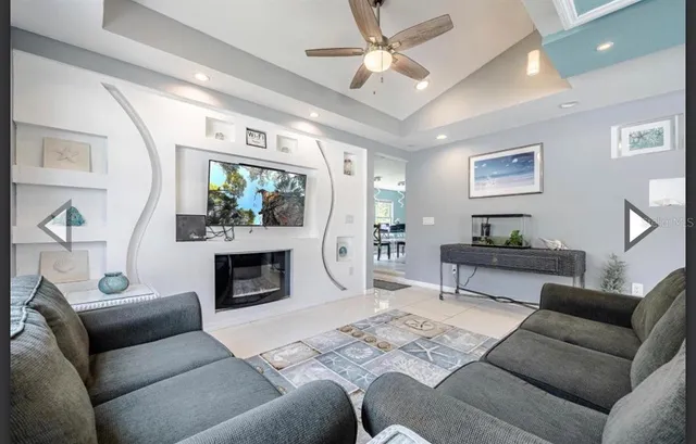 a living room with furniture a fireplace and a ceiling fan