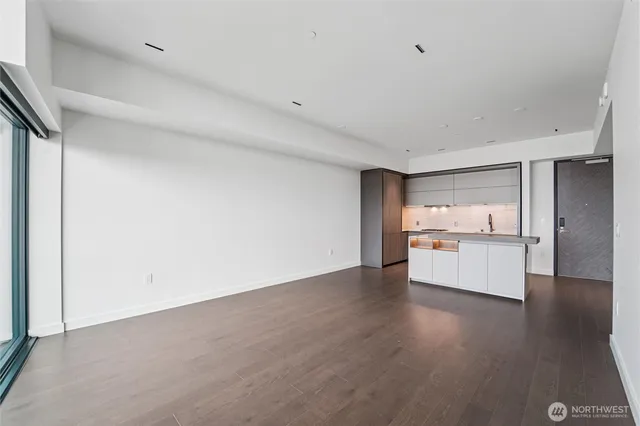 a view of a kitchen with a sink and dishwasher a refrigerator with wooden floor