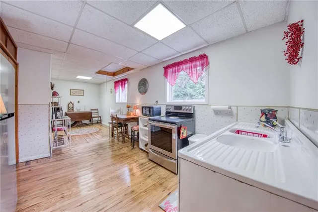 a kitchen that has a lot of cabinets a sink and a stove with wooden floor