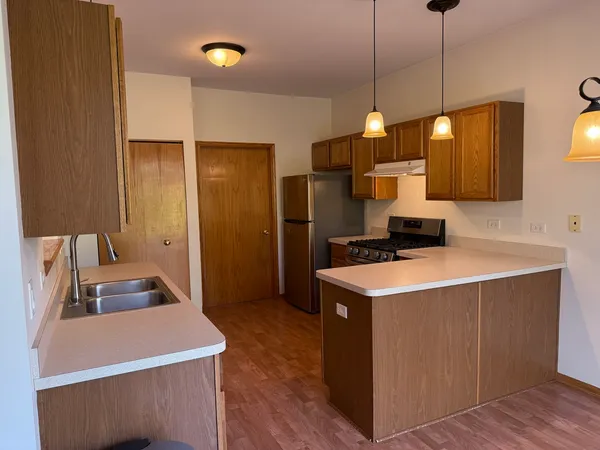 a kitchen that has a sink a stove and a wooden floor