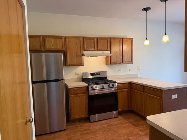 a kitchen with refrigerator cabinets and wooden floor