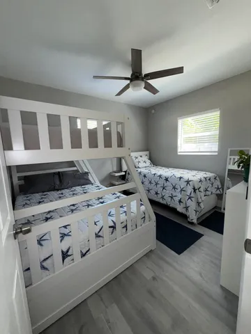 a bedroom with a bed next to a window and a chandelier