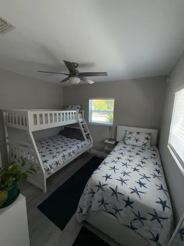 a bedroom with a bed and a dresser next to a window