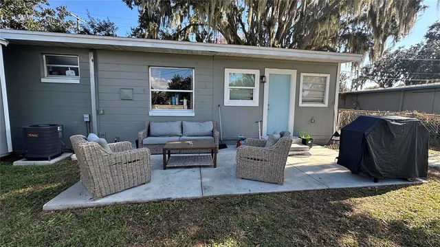 a view of a patio with couches chairs and a yard