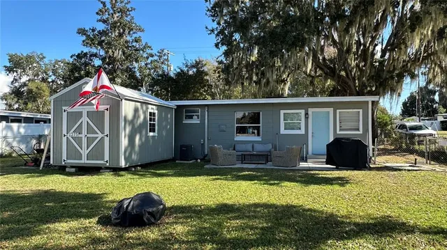 a view of a house with backyard and sitting area