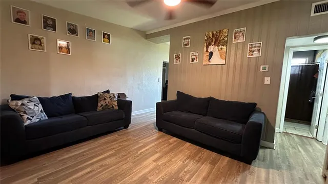 a living room with furniture and wooden floor