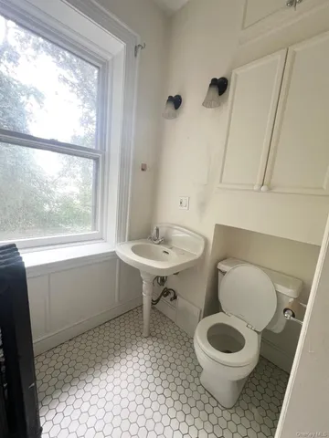 a bathroom with a sink toilet and a window