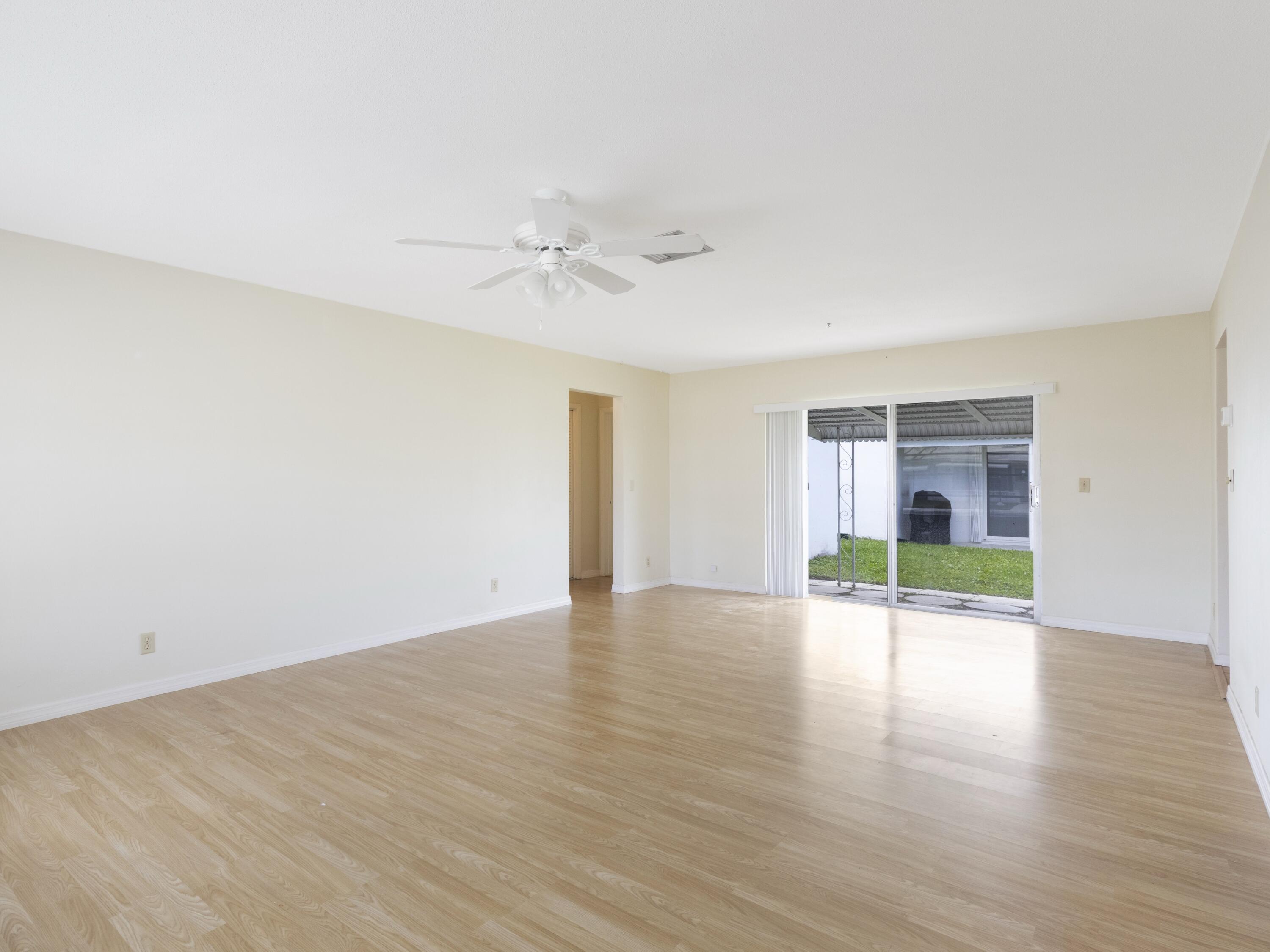 127 Leisureville Boulevard Boynton Beach, FL 33426 - Photo 3 of 23 a view of an empty room with a window and wooden floor