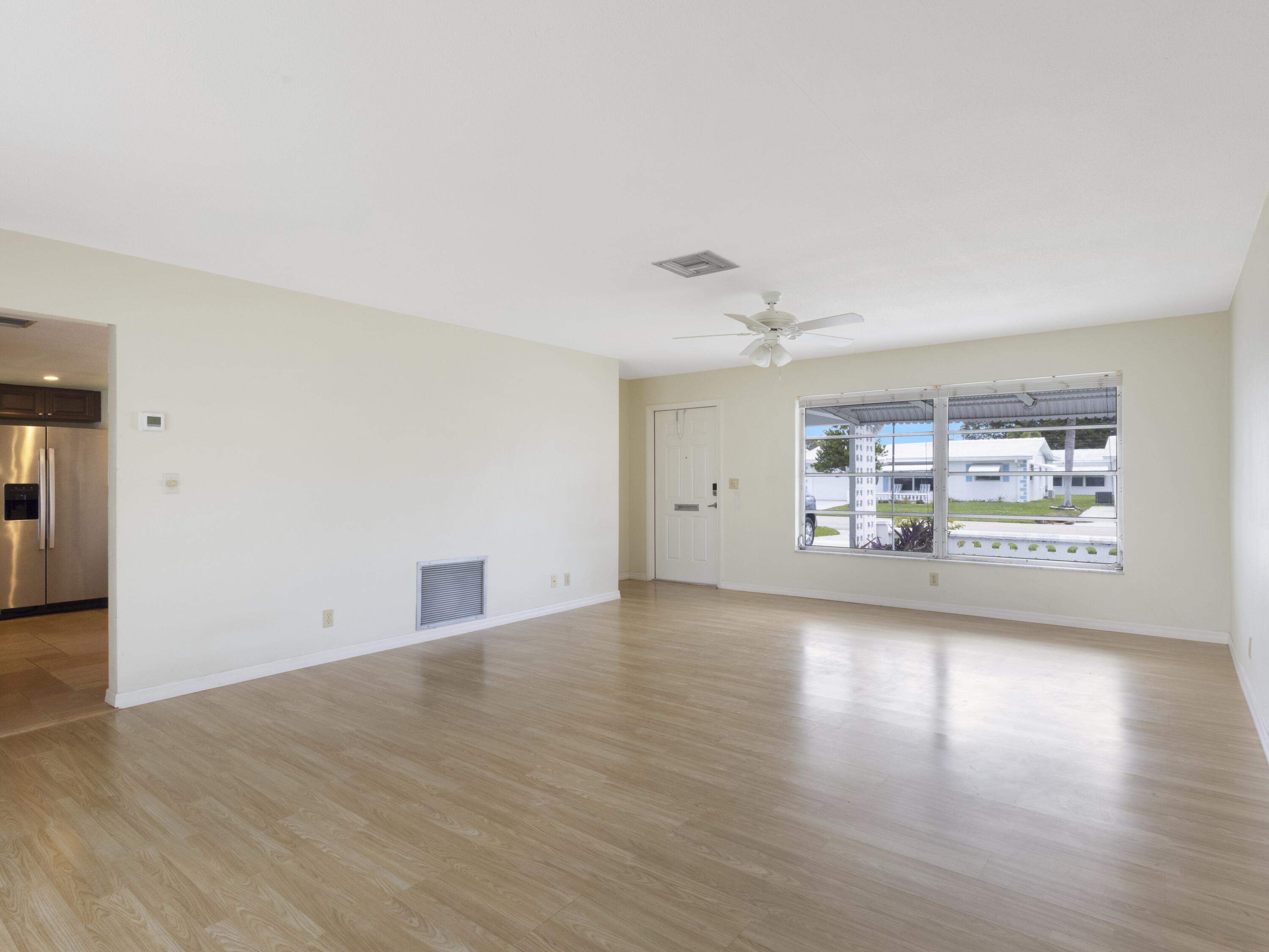 127 Leisureville Boulevard Boynton Beach, FL 33426 - Photo 5 of 23 a view of empty room with wooden floor and fan