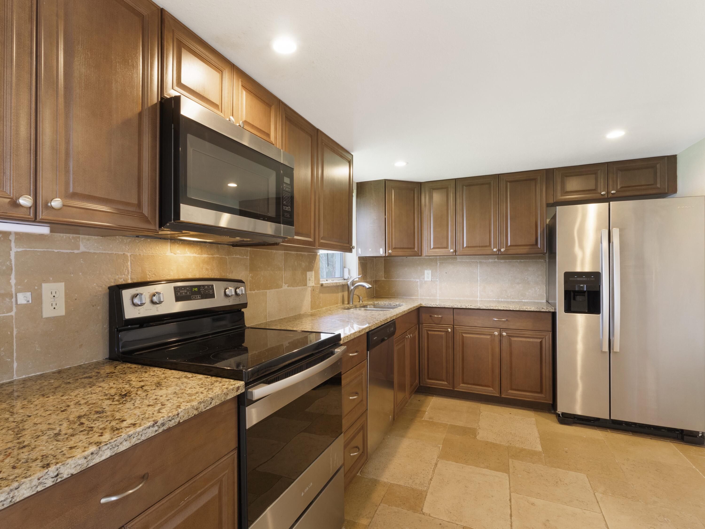 127 Leisureville Boulevard Boynton Beach, FL 33426 - Photo 6 of 23 a kitchen with a refrigerator stove and microwave
