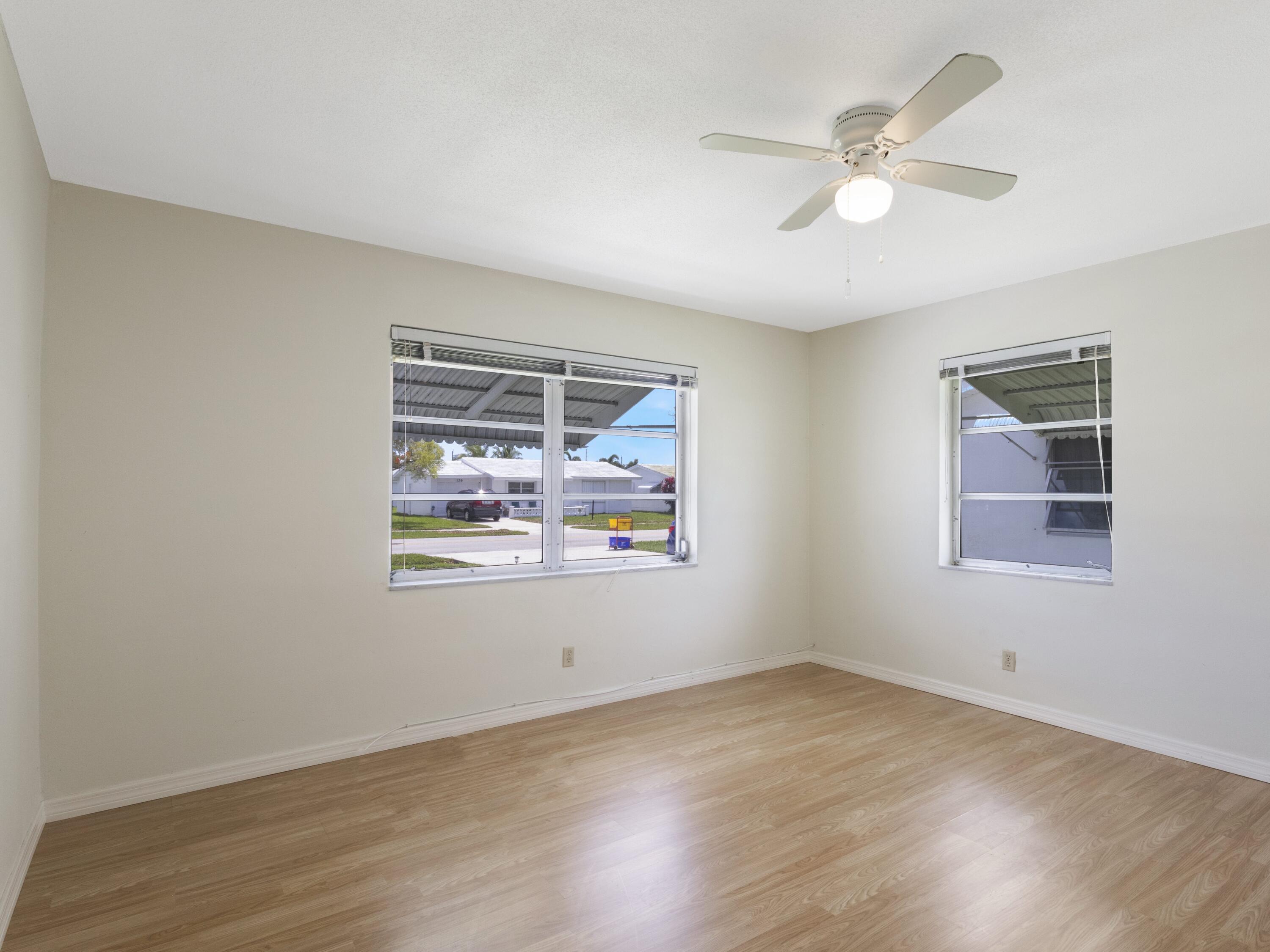127 Leisureville Boulevard Boynton Beach, FL 33426 - Photo 8 of 23 an empty room with wooden floor and windows