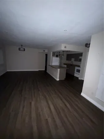 a view of room with wooden floor and white walls