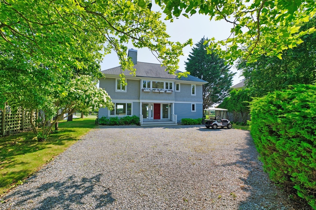 a view of a brick house next to a yard with big trees