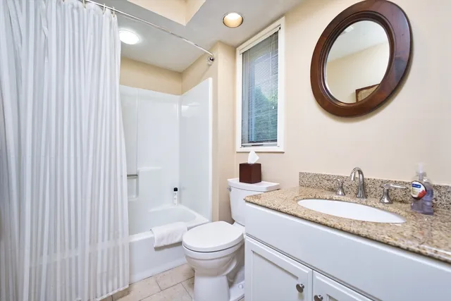 a bathroom with a granite countertop sink a toilet and a mirror