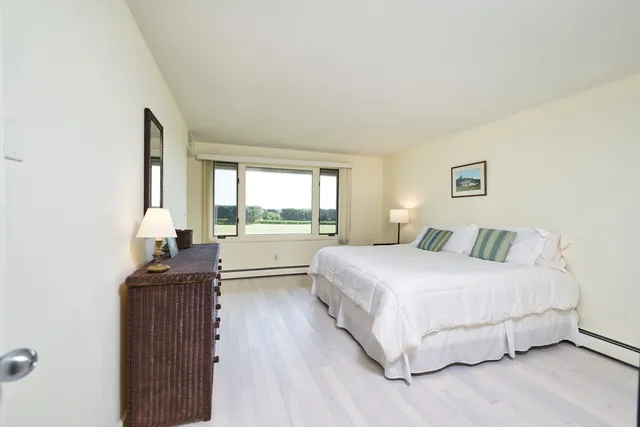 a bedroom with a bed and a dresser next to a window