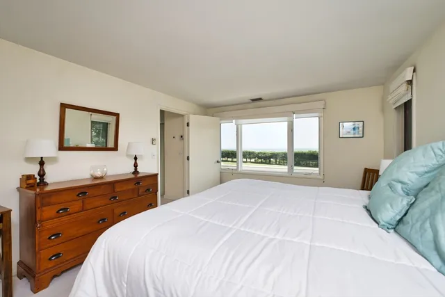 a bedroom with a bed and a dresser with mirror