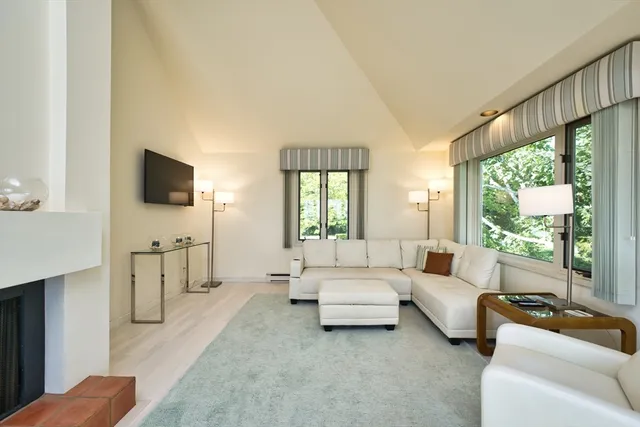a living room with furniture a flat screen tv and a large window