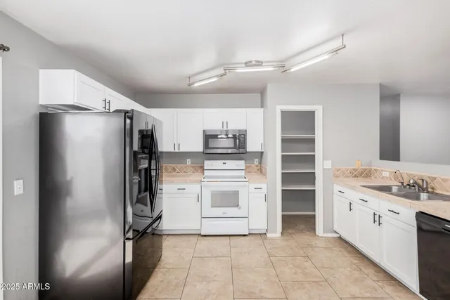 a kitchen with stainless steel appliances a refrigerator sink and stove