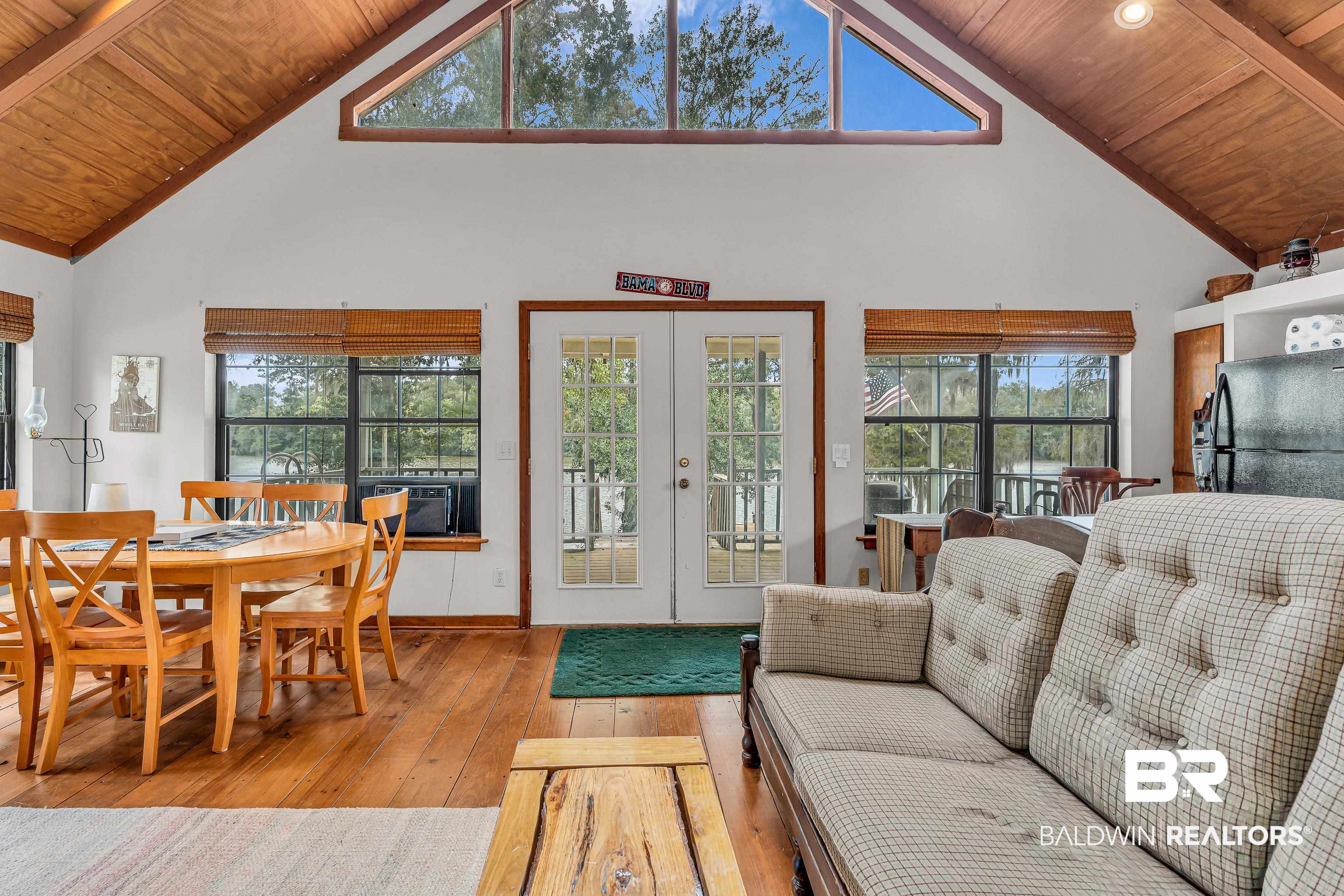 8317 Bryant's Lndg Road Stockton, AL 36579 - Photo 17 of 28 Living area featuring a wooden ceiling with exposed beams, high vaulted ceiling, hardwood / wood-style floors, cooling unit, and french doors