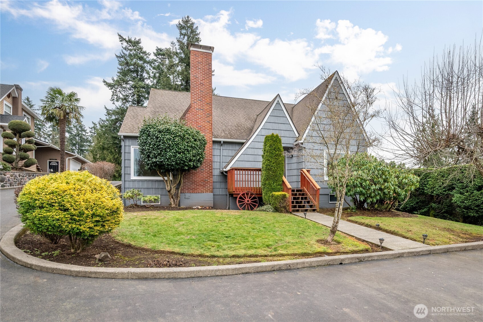 a front view of a house with a yard and trees