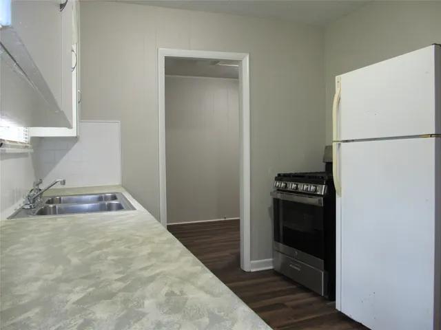 a kitchen with a refrigerator and a sink