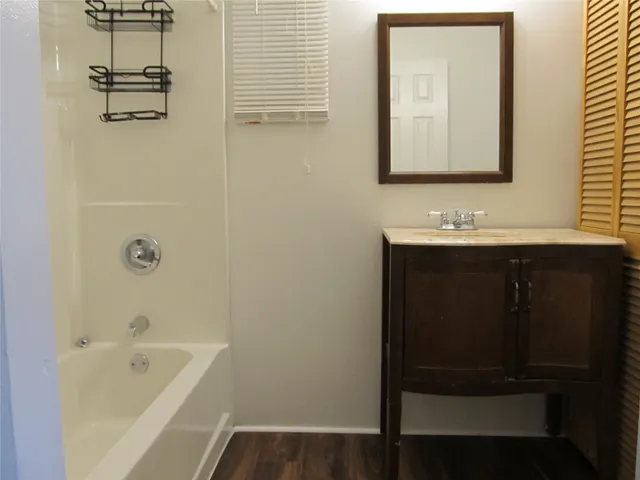 a bathroom with a tub sink and mirror
