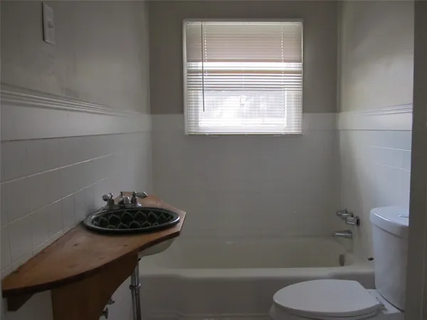a bathroom with a sink a toilet and a window