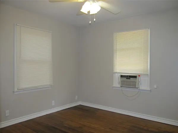 a view of a room with wooden floor and windows