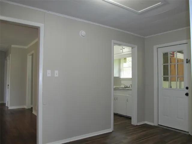 an empty room with wooden floor closet and windows