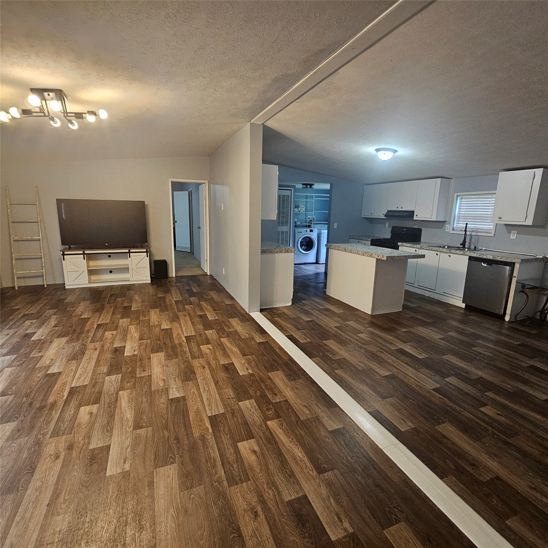 139 Malcom Street Ames, TX 77575 - Photo 24 of 26 a large room with kitchen island a sink wooden floor and chairs