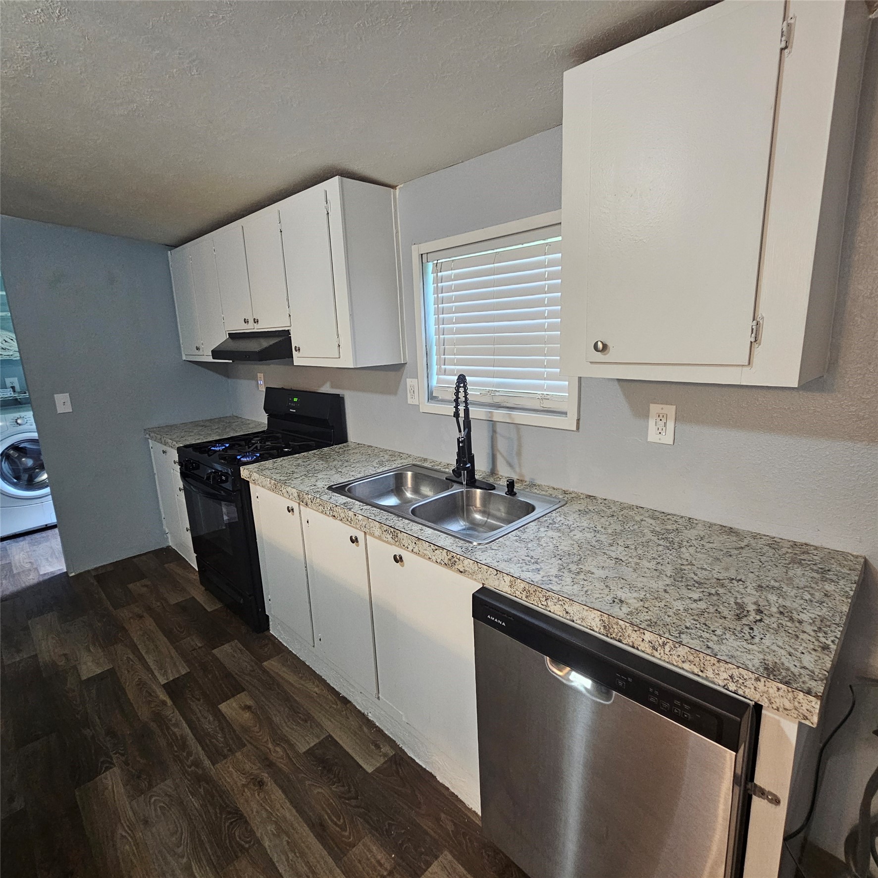 139 Malcom Street Ames, TX 77575 - Photo 6 of 26 a kitchen with stainless steel appliances granite countertop a sink stove and cabinets