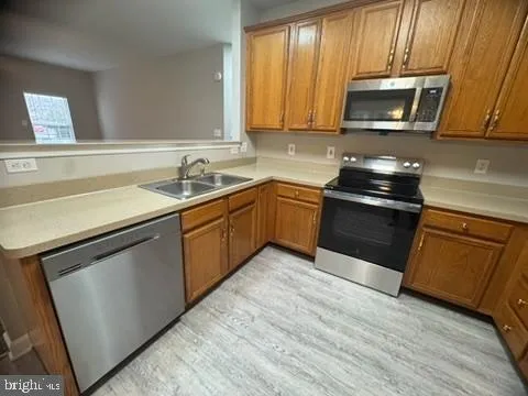 a kitchen with stainless steel appliances granite countertop wooden cabinets stove top oven and sink