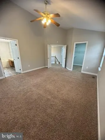 a view of a room with a ceiling fan and a bathroom