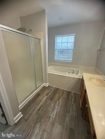 a bathroom with a tub sink and shower