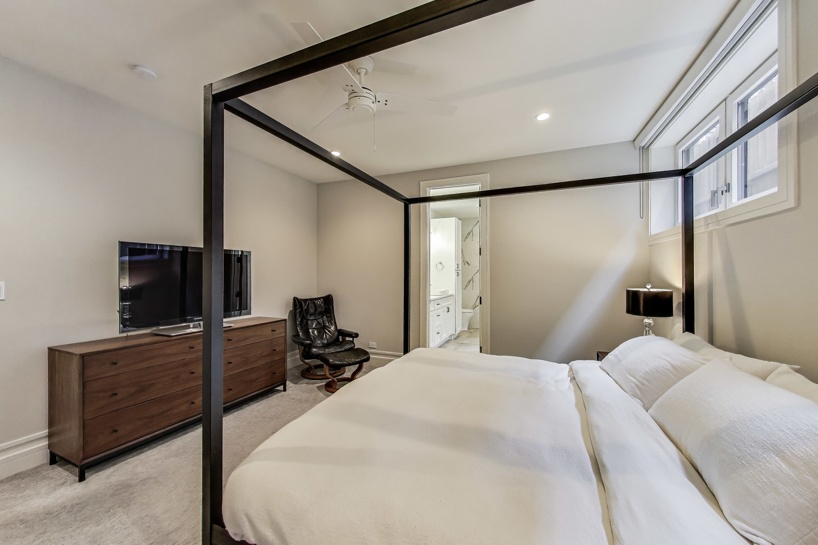 1474 West Ohio Street, Unit 1 Chicago, IL 60642 - Photo 18 of 37 a bedroom with a bed and a flat tv screen on dresser