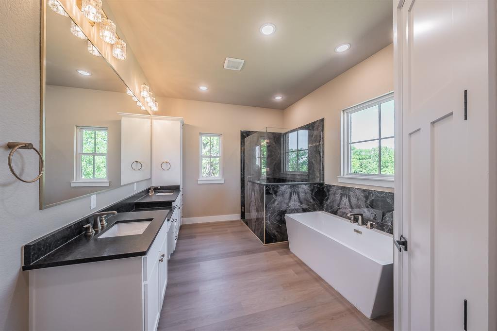 114 Ridgeline Drive Chico, TX 76431 - Photo 15 of 38 Primary bath features stand alone tub, beautiful enclosed shower, and dual vanities with granite countertops.