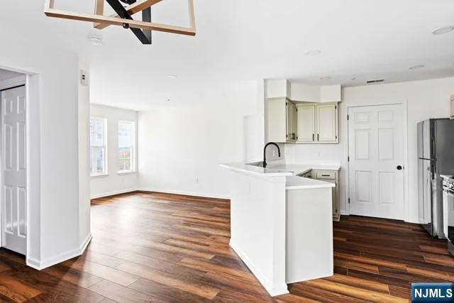 a kitchen with white cabinets and sink