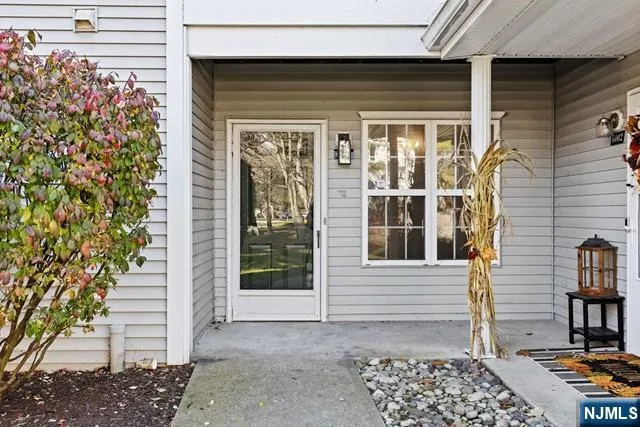 a view of a house with a door and wooden bench